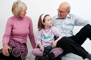 Grandparents sitting on the floor with their granddaughter
