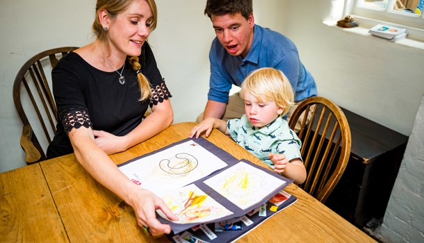William learning his letters with his parents at a dining table.
