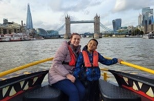 Emma and Isaac (6) on a boat on the Thames with London Bridge behind them.